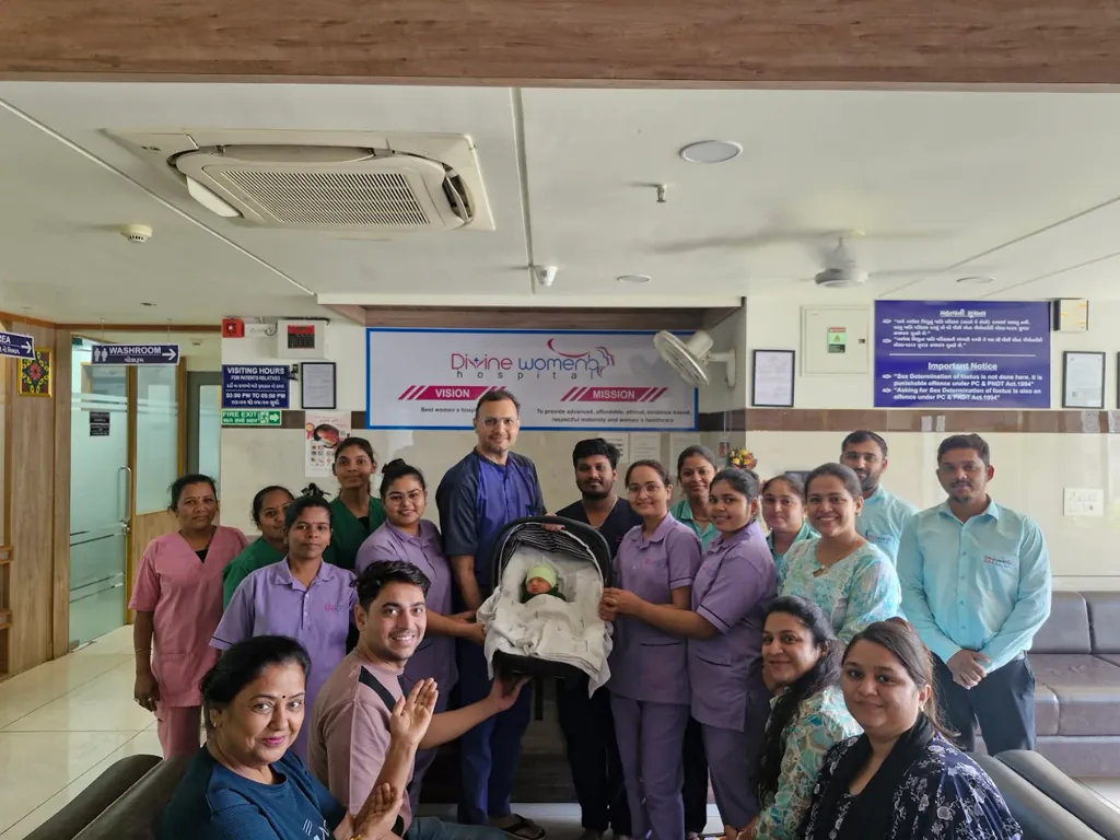 The Divine Women's Hospital team with a newborn baby and family at the hospital reception